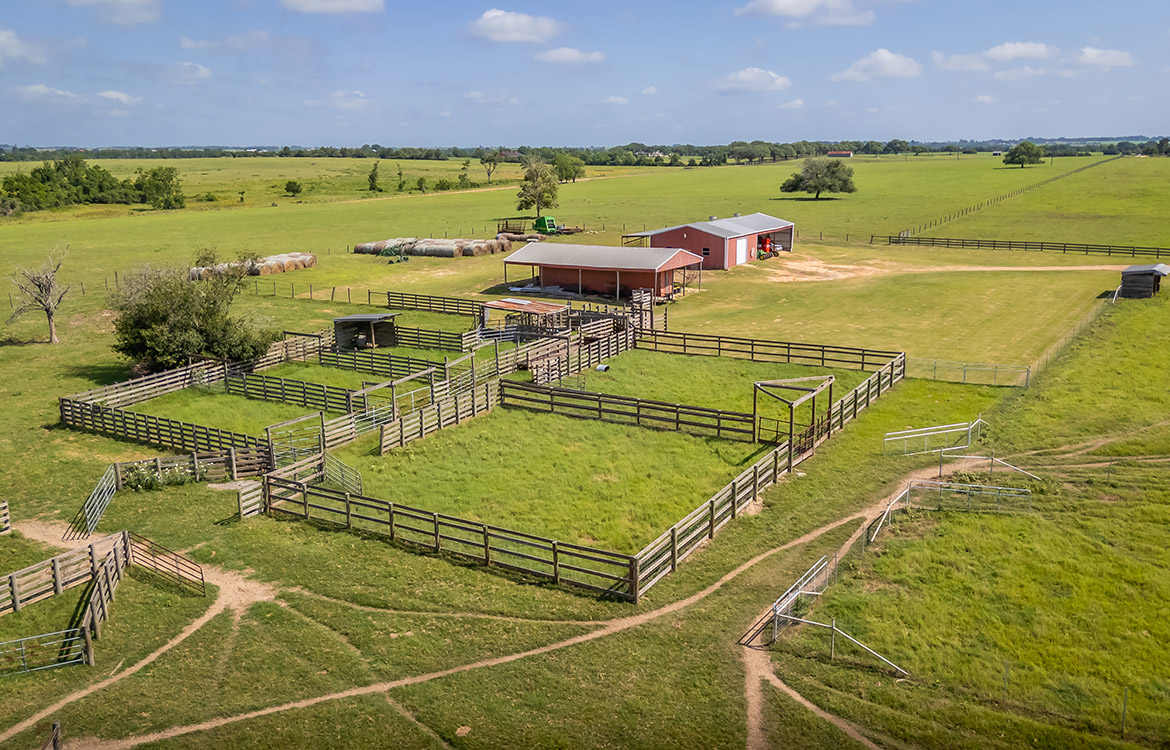 Aerial view of Texas ranch land with fencing and barn